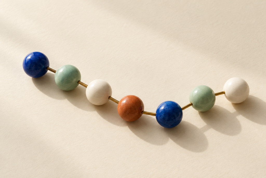 Coloured connected beads representing a simplified chain of building blocks.